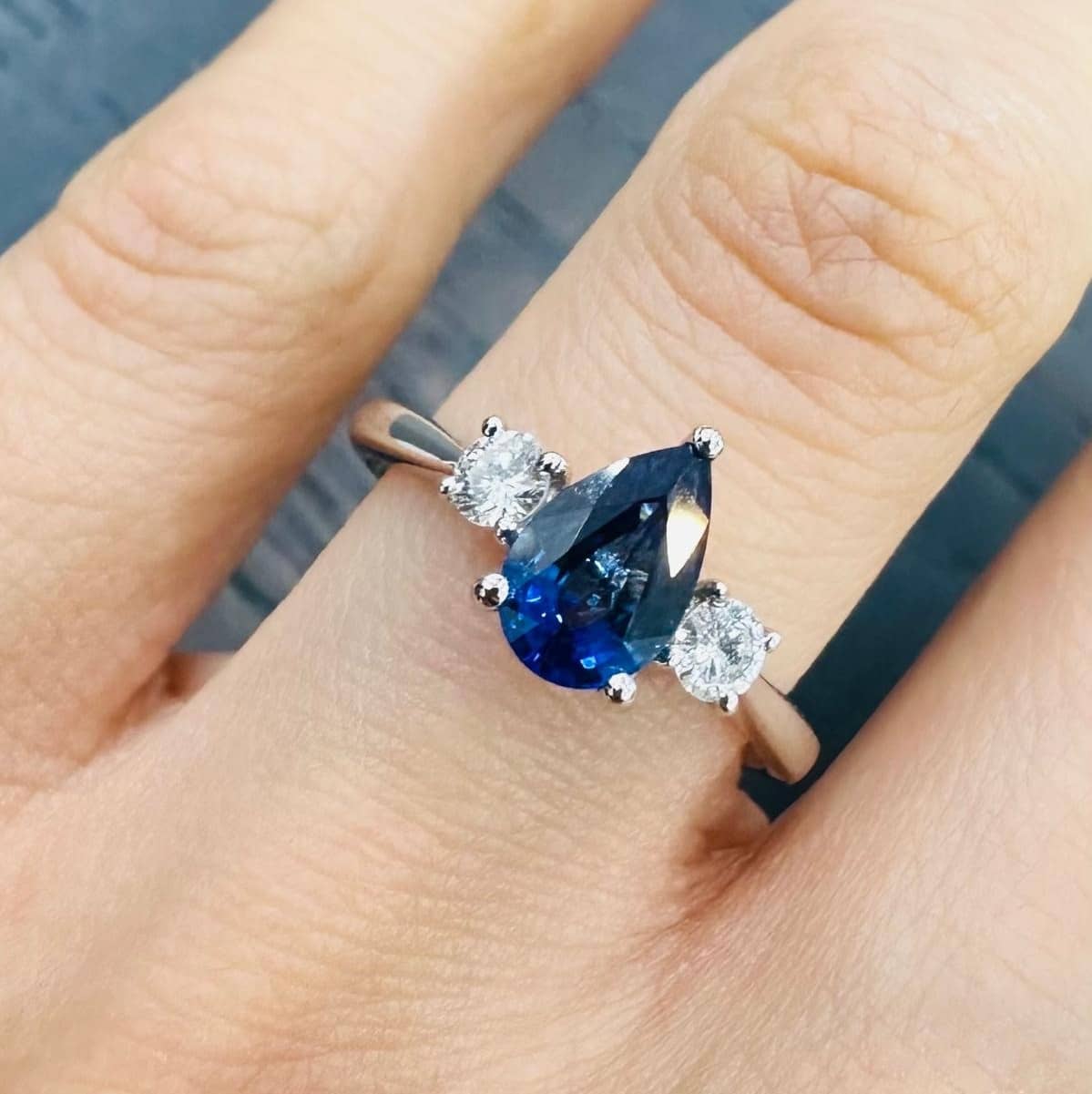 1.00 CARAT NATURAL PEAR BLUE SAPPHIRE AND SIDE ROUND DIAMOND TRILOGY RING IN PLATINUM